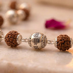 Rudraksha mala by Saadhak with silver-plated "Om Namah Shivaya" engraved beads for devotion, peace, and spiritual wear.