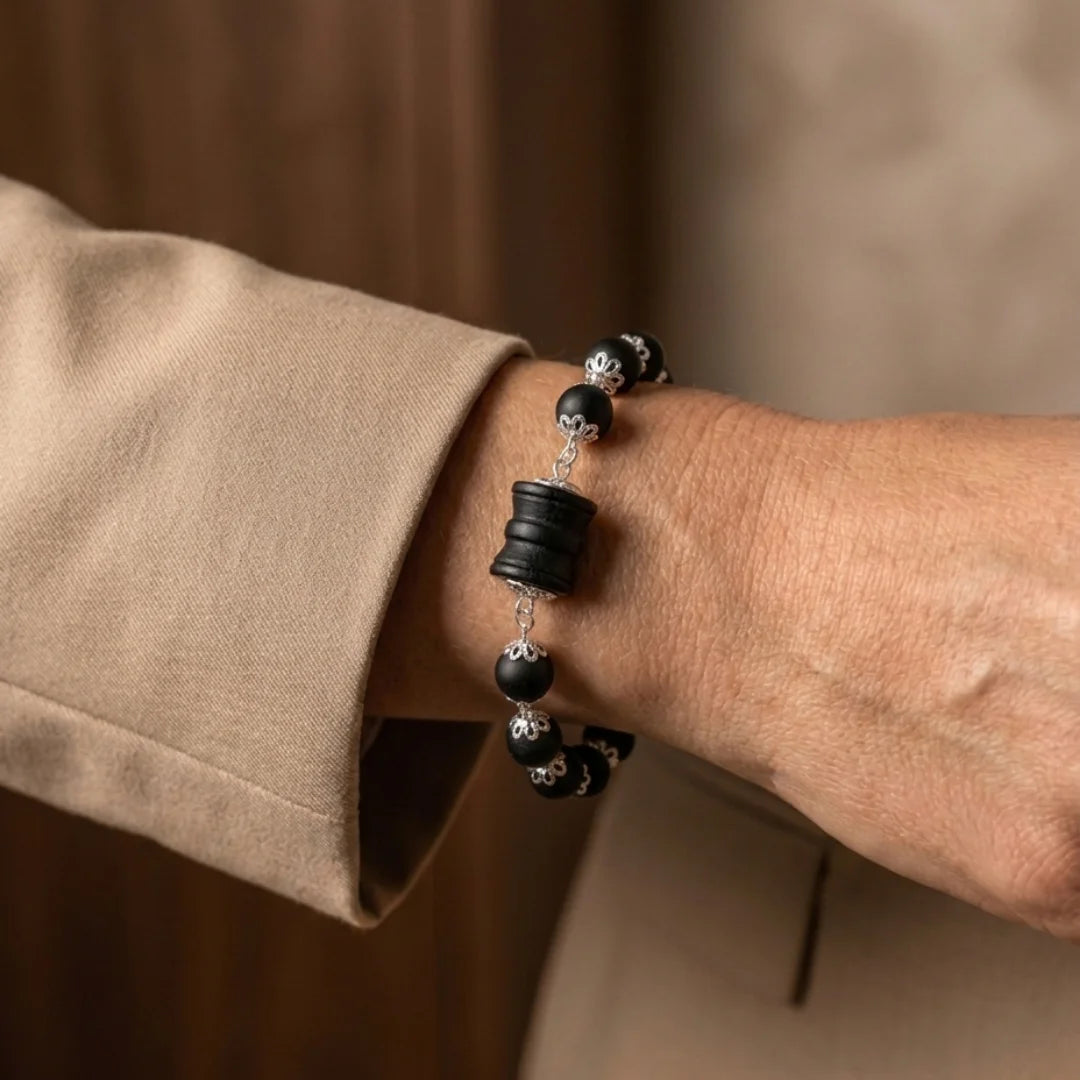 Handcrafted Slim Silver Cap Karungali bracelet by Saadhak featuring authentic ebony wood beads and a sacred Damru charm.